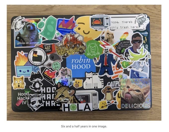 A Robinhood employee laptop covered in stickers, including four raccoon stickers